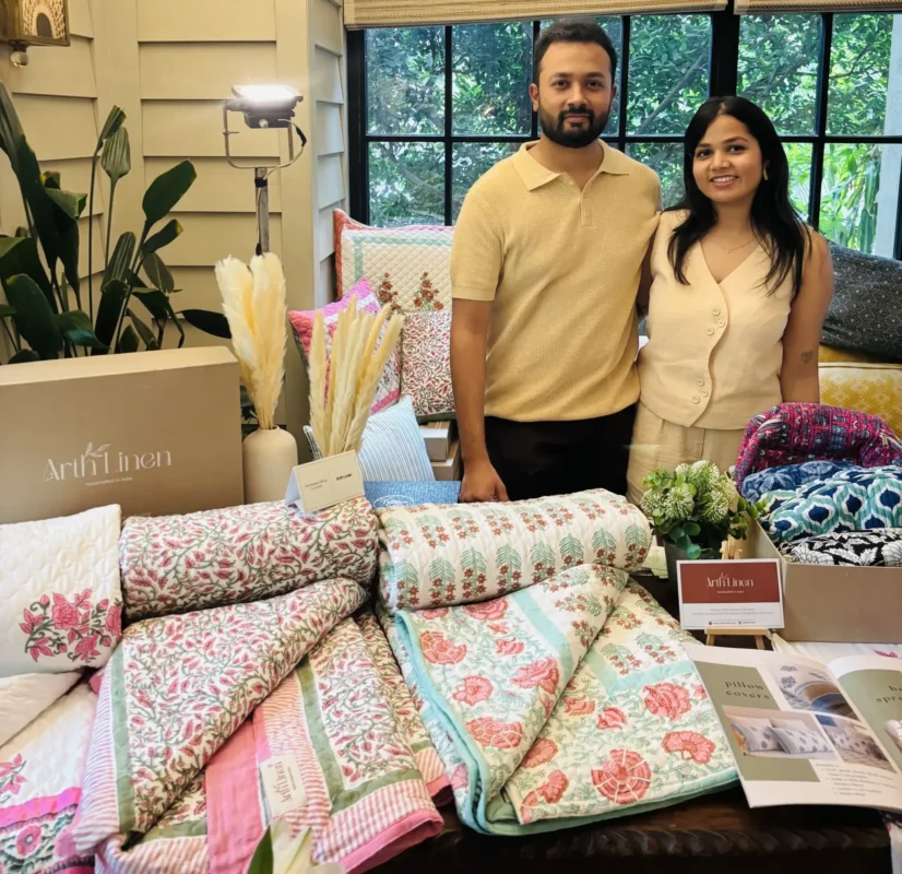 Arth Linen founders with hand block printed quilts and cushion covers