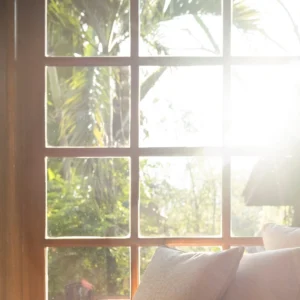 Sunlight through a wooden window onto cushions