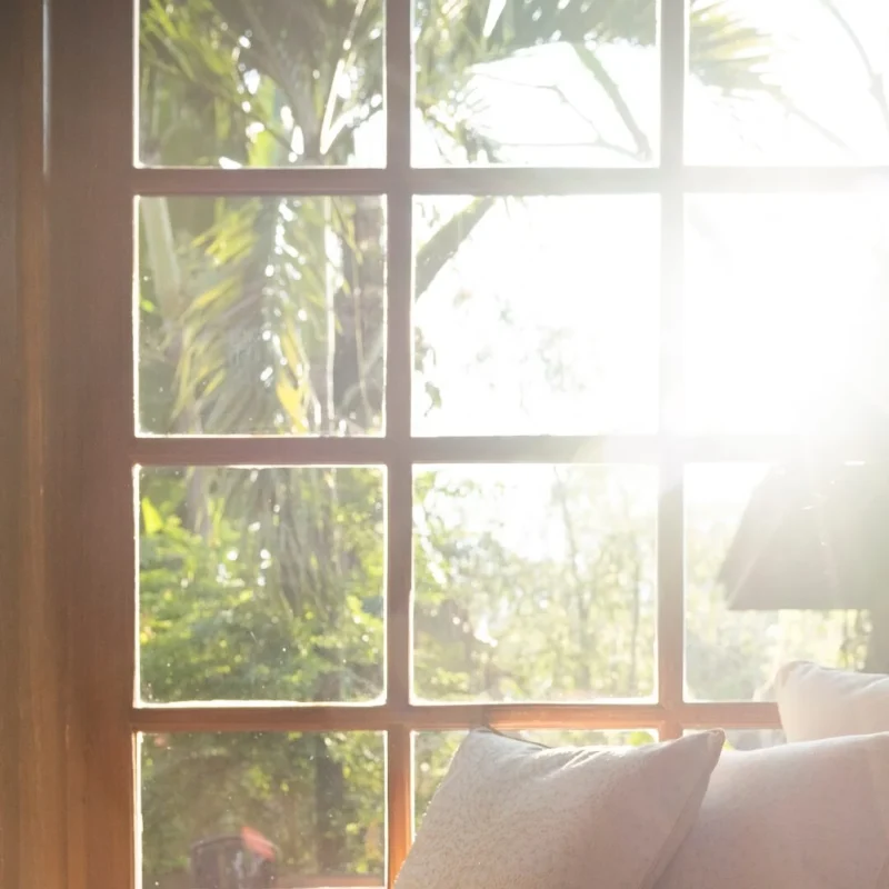 Sunlight through a wooden window onto cushions