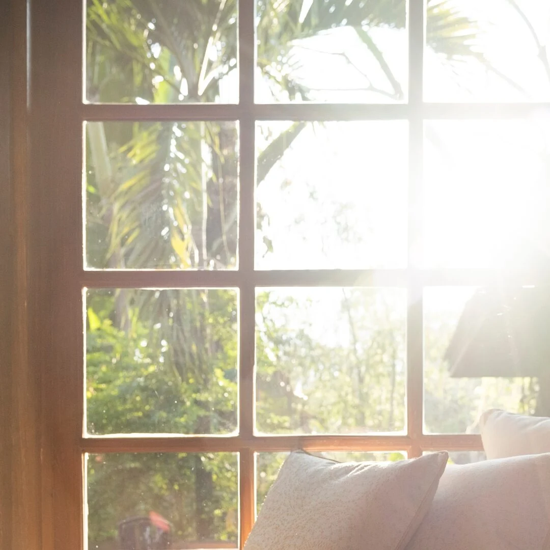 Sunlight through a wooden window onto cushions