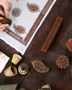 Carved wooden printing blocks beside hand block printed fabric